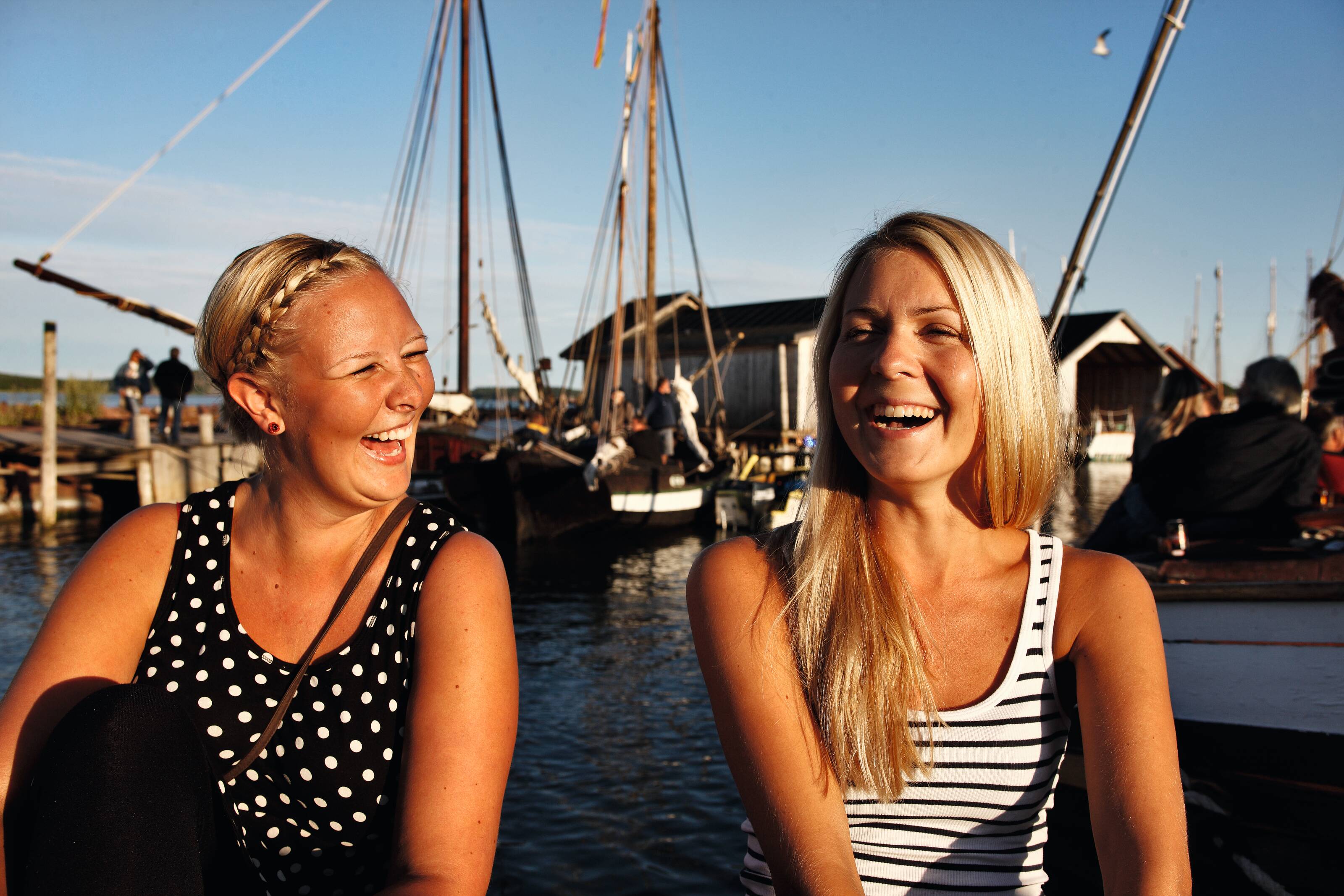 Zwei lachende Frauen am Yachthafen im Åland-Archipel.