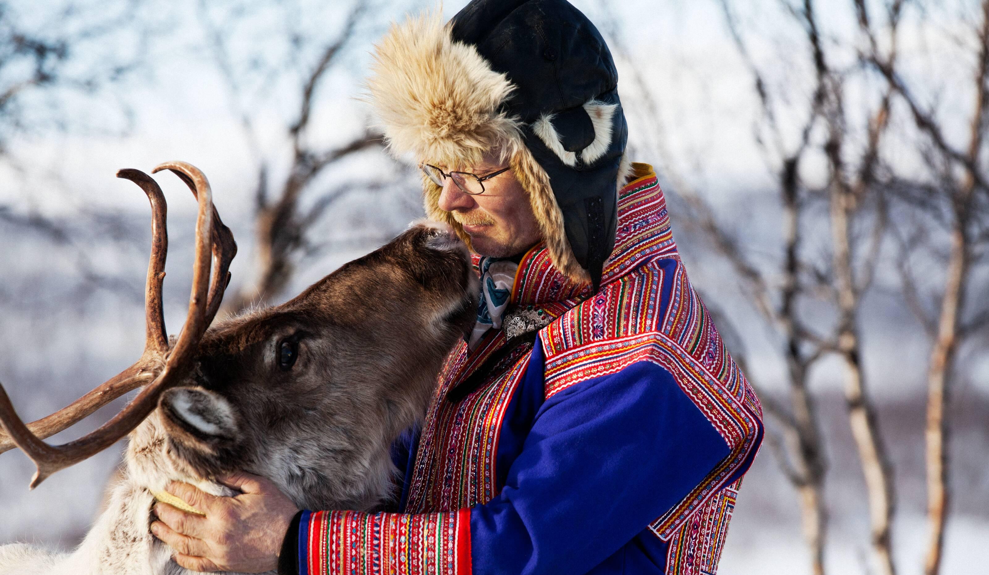 Sámi-Mann mit seinem Rentier.