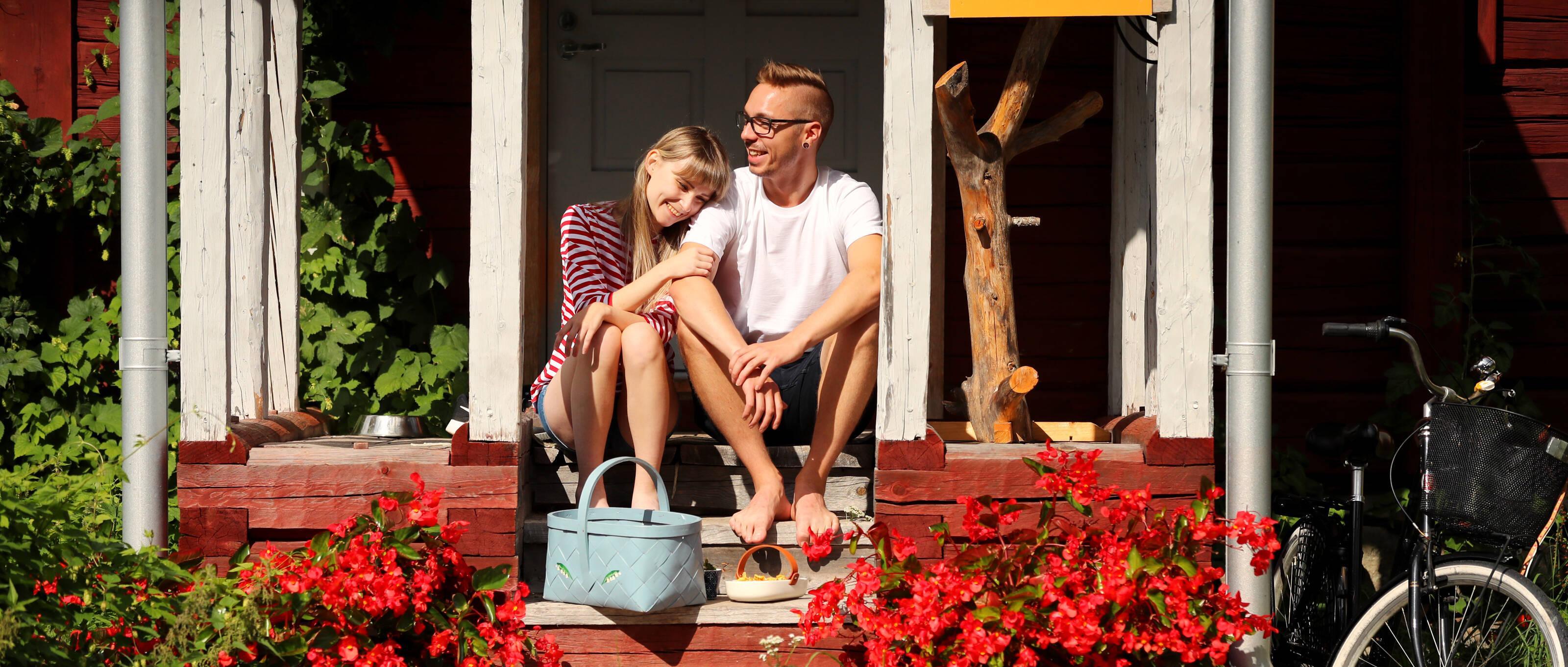 Junges Paar sitzt auf der Veranda eines Hauses