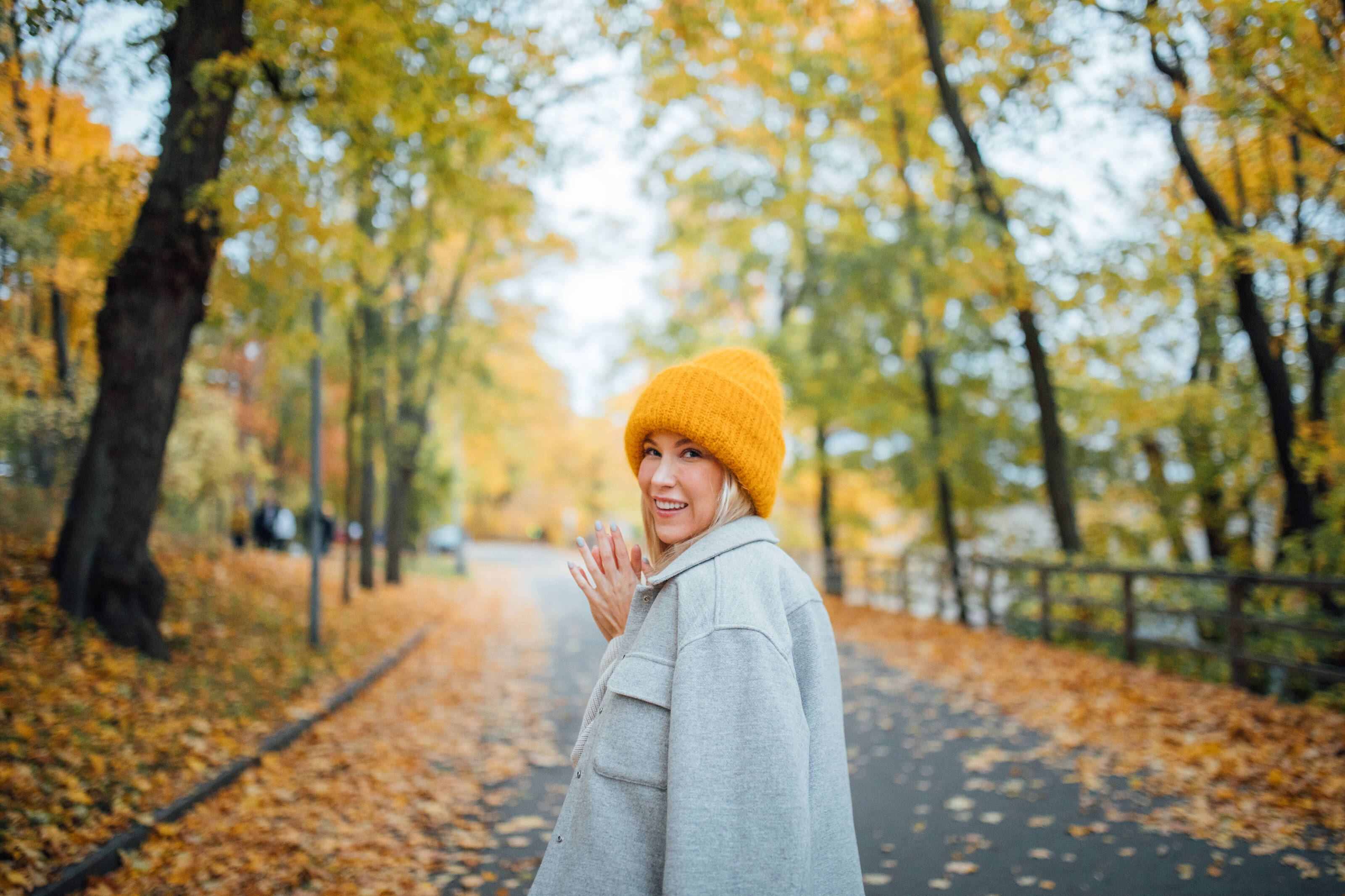 Frau, die durch eine Herbstlandschaft geht.