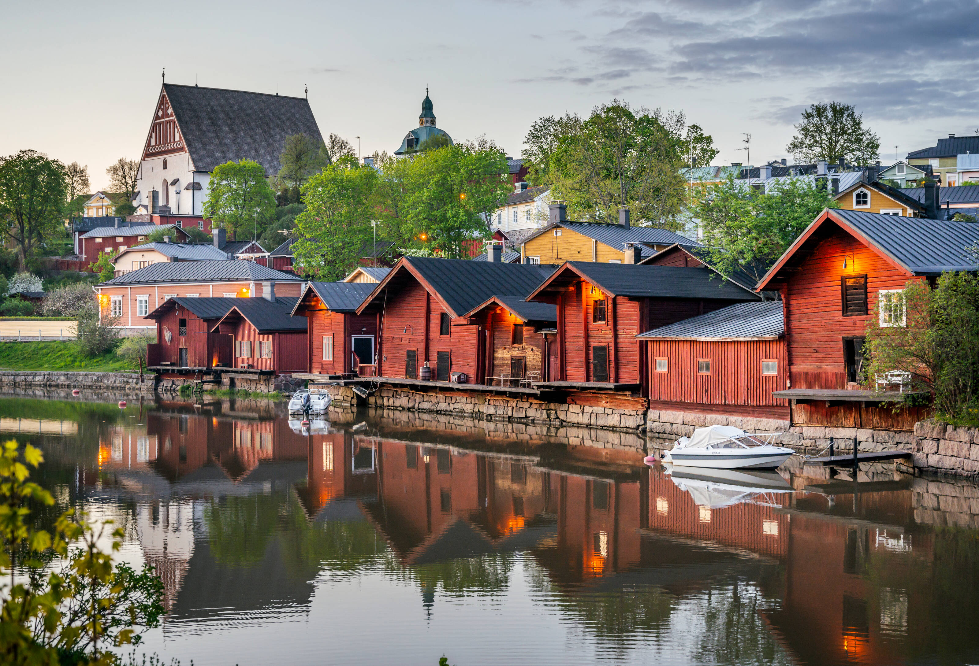 Idyllische rote Ockerholzgebäude an einem Flussufer im finnischen Porvoo