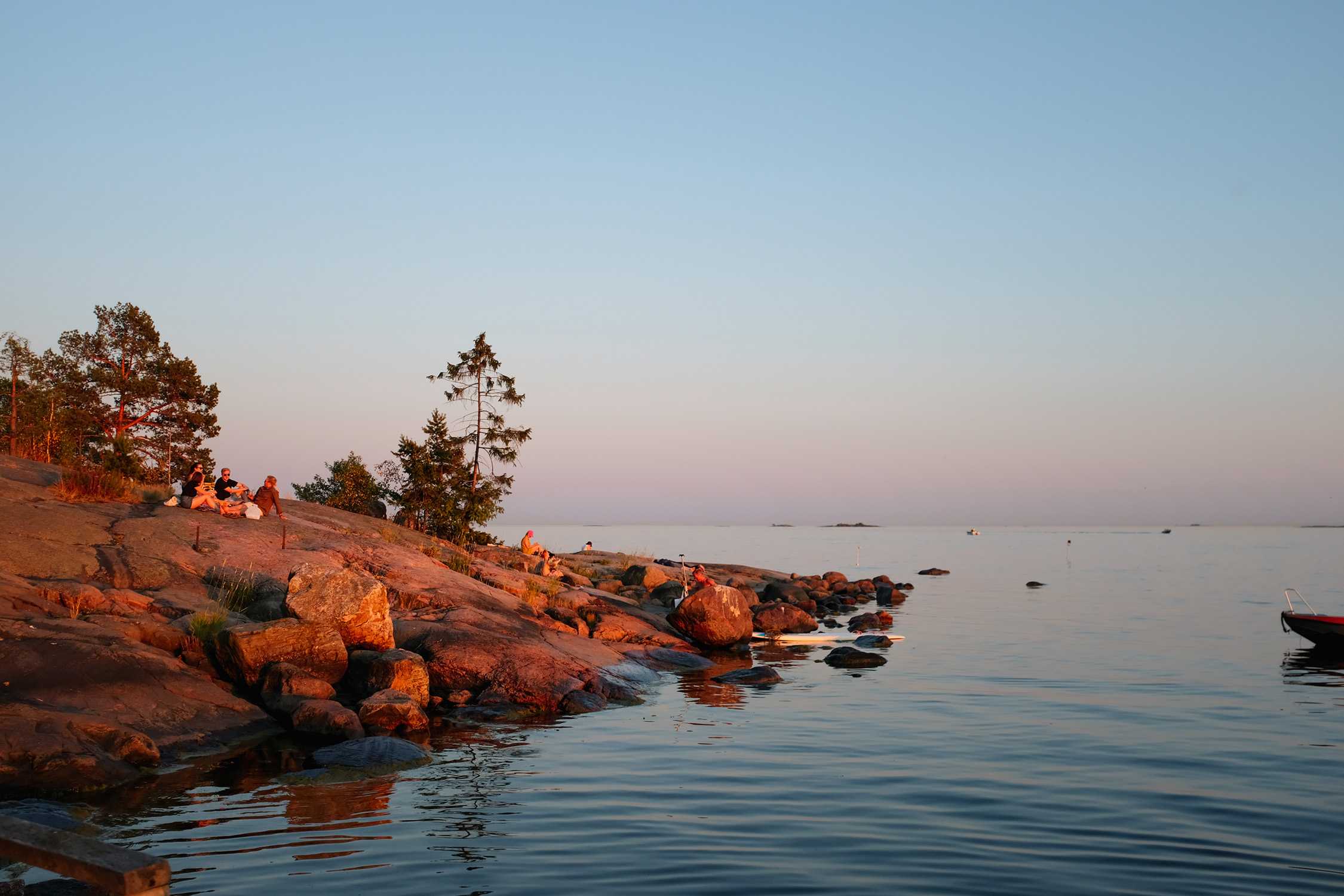 Una serena veduta marina di Helsinki illuminata dallo splendido bagliore del sole di mezzanotte.