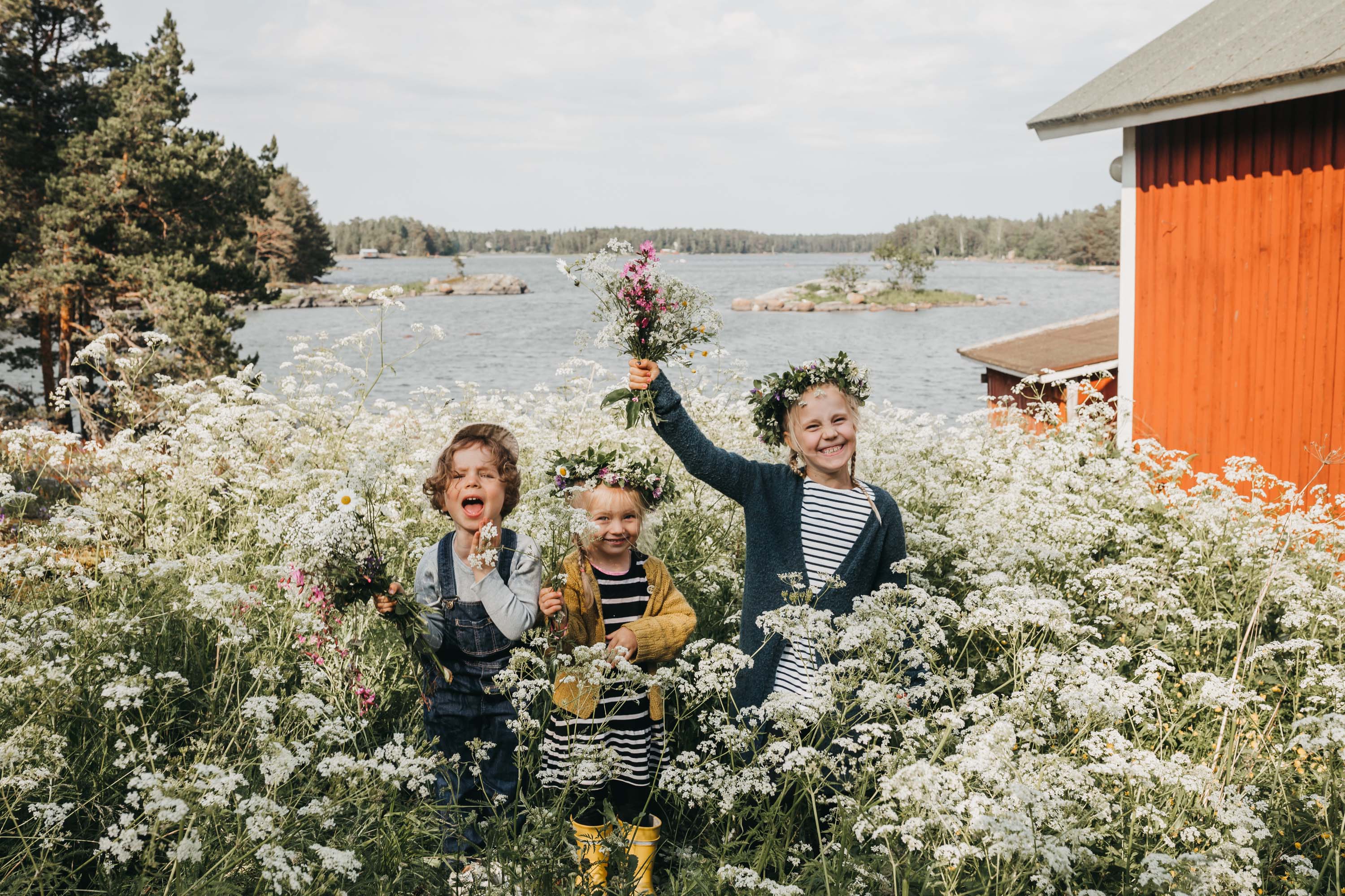 Lachende Kinder auf einer Blumenwiese an der finnischen Ostsee