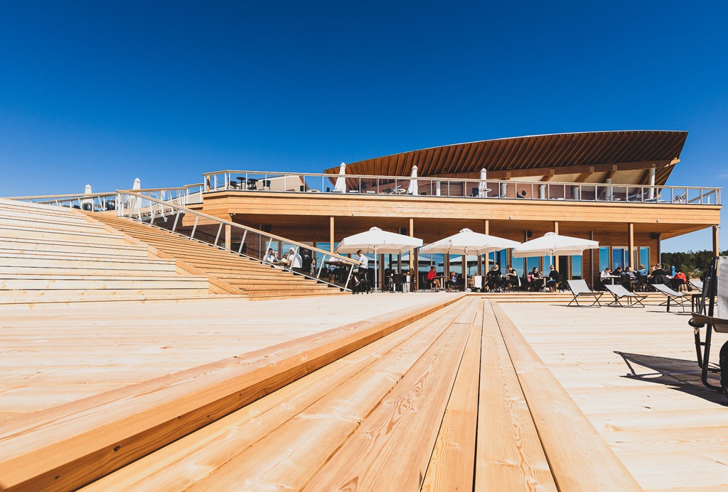 Eine riesige Holzterrasse einer öffentlichen Sauna voller Menschen