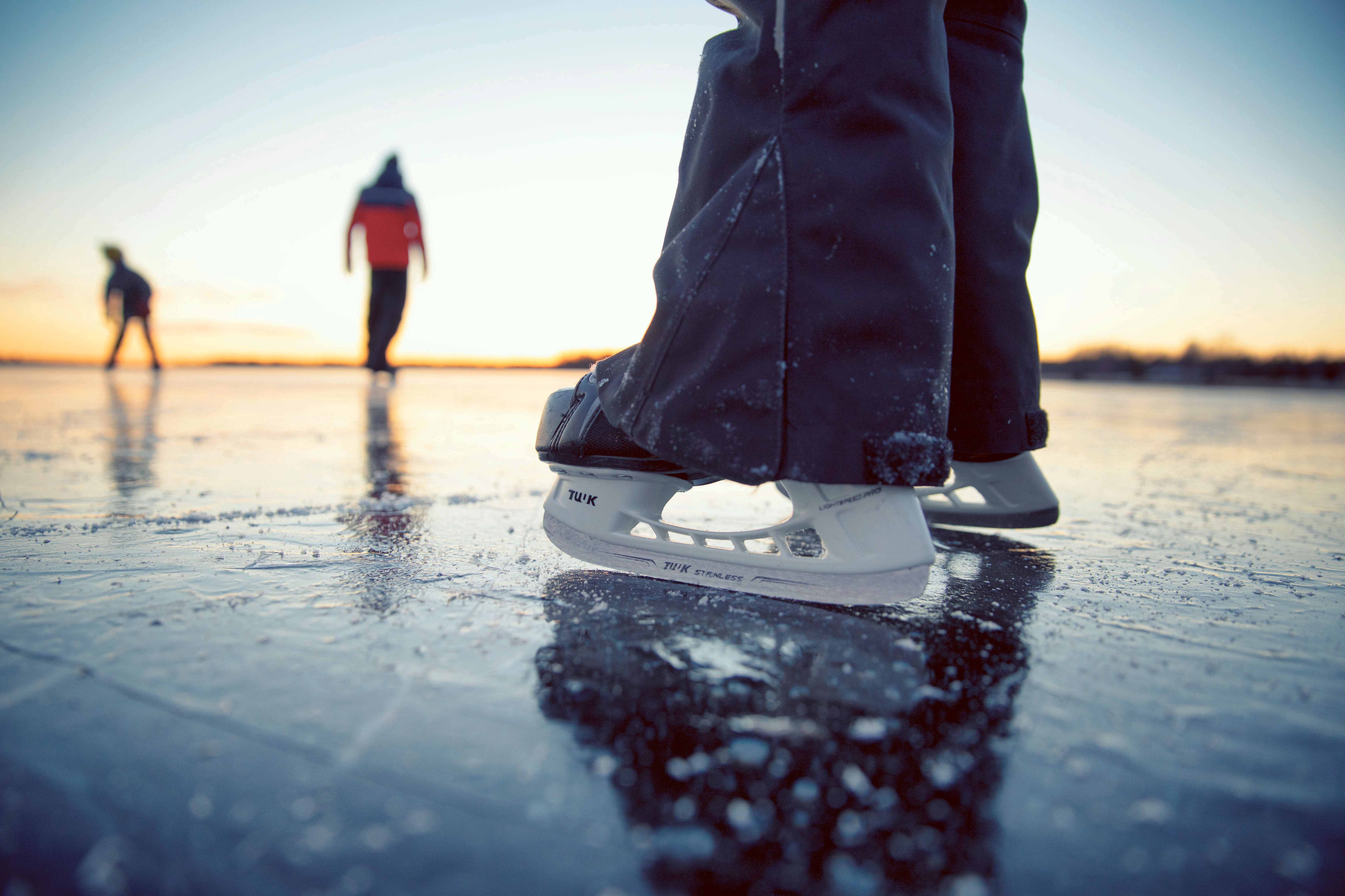 Nahaufnahme der Schlittschuhe eines Skaters auf dem Eis eines Sees