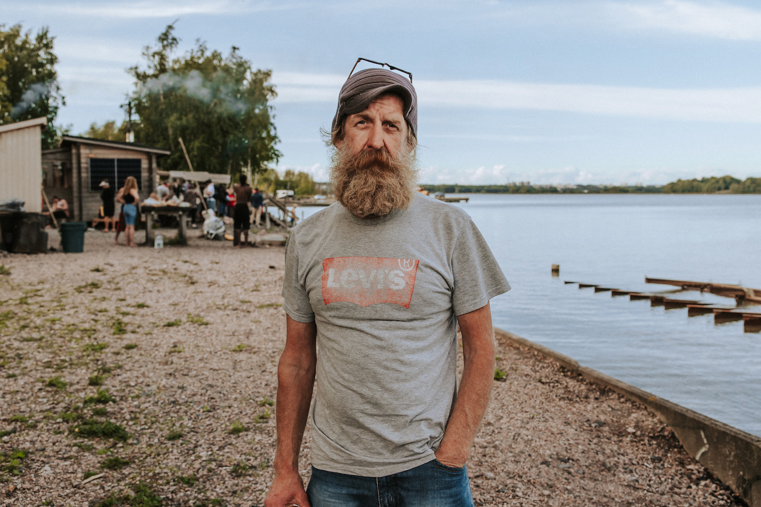 Man with a beard standing on a beach.