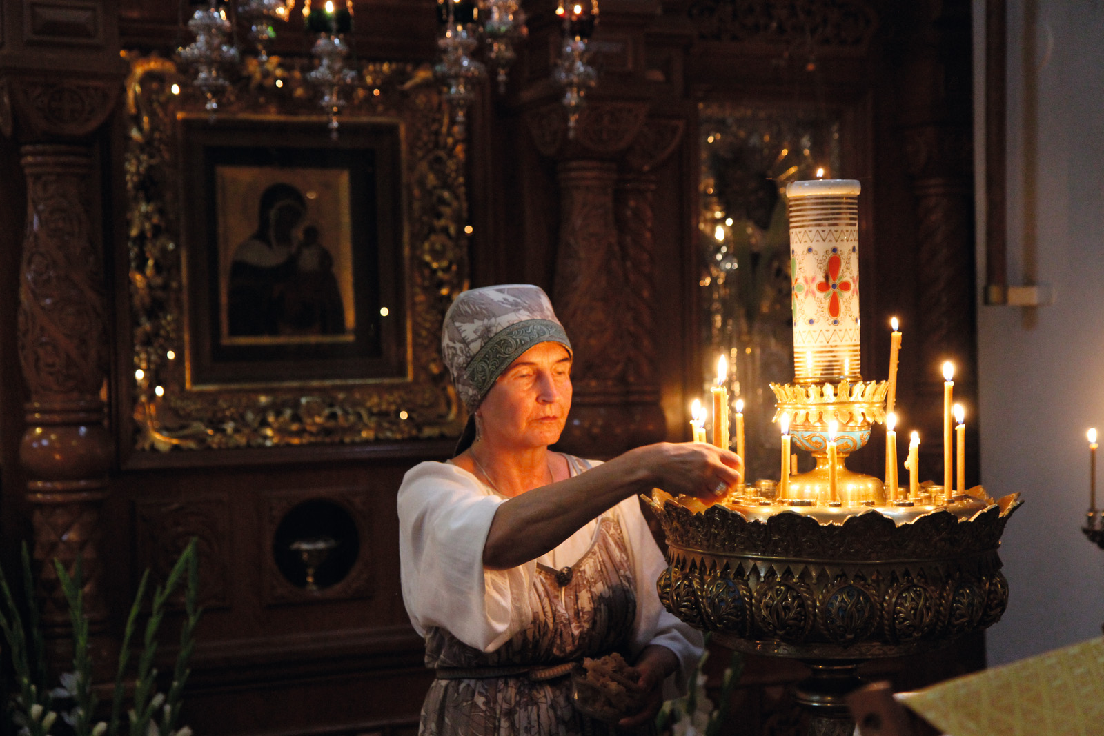 Eine Person zündet Kerzen im Kloster Valamo an. - Valamo Monastery